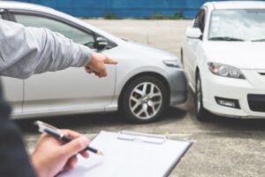 Insurance Agent examine Damaged Car and filing Report Claim Form after accident