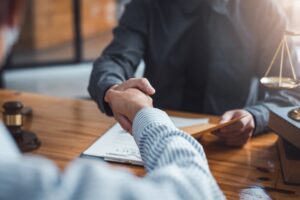 A lawyer shaking hand with a client after legal agreement.