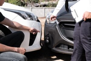 Car insurance adjuster is checking assess the damage for accident claim and processed