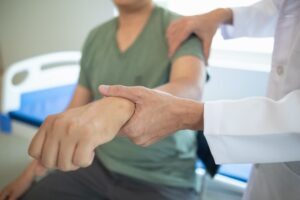 A doctor assists a patient with muscle rehabilitation through physical therapy.