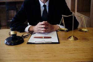 Legal counsel presenting a signed contract to a client with a gavel and legal documents, symbolizing justice and the lawyer concept.