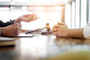 Business people and lawyers sitting at a table, discussing contract papers. This image represents concepts of law, legal advice, and legal services.