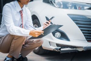 A young businesswoman is seated at her desk, reviewing various car insurance options. She is comparing premiums, deductibles, and coverage details while ensuring she understands the policies and manages claims effectively.