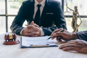 Businessmen and lawyers discuss contract documents and sign agreements. Male lawyers consult with clients in an office meeting.