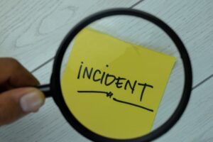 Incident write on sticky notes isolated on Wooden Table.