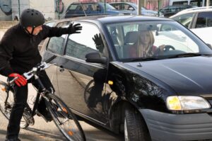 Female car driver puts a cyclist in a dangerous situation near the accident in traffic