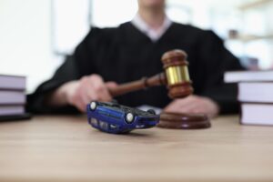 Upside down toy car and female judge with gavel at courtyard