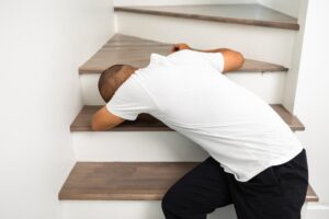 A young man slip and fall on the stairs of the house.