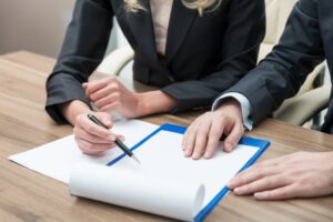 Close-up of hands during a legal contract negotiation, symbolizing teamwork.