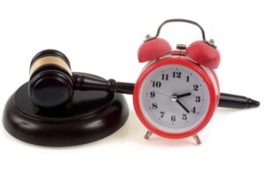 Judge's gavel on its plinth next to a bell clock