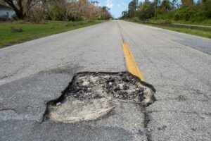 Dangerous pothole on an American road, indicating a driveway in urgent need of repair