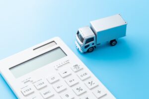 Truck and calculator on blue background.