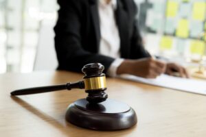 Judge's gavel on the table, symbolizing a lawyer defending a client to win the case and achieve the best legal outcome.