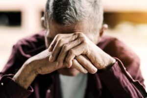 senior man covering his face with his hands