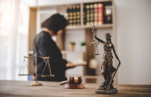 Lady Justice holding scales in a courtroom, symbolizing equality, fairness, and legal proceedings.