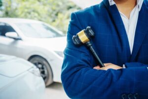 Car accident attorney holding judge's hammer. Cars in background