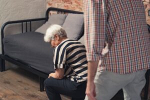 Elderly Caucasian woman collapses after arguing with her middle-aged son.