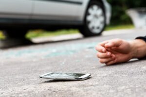 A person hit by a car while crossing the road and talking on the phone.